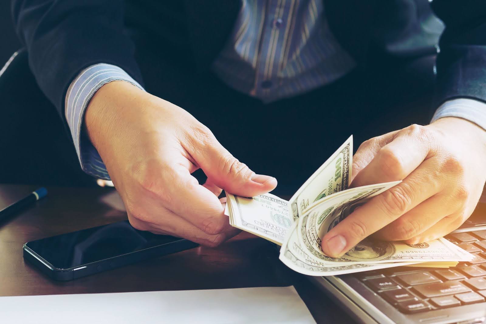 Man wearing suit counting banknotes